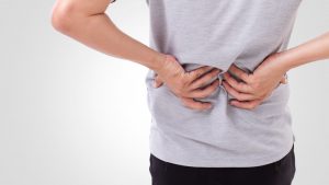 Man in pain holding his lower back