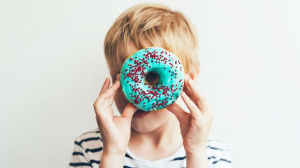 Boy looking through a donut